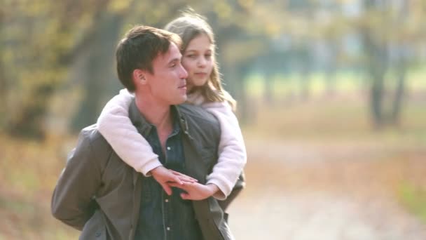 Vader biedt dochter piggyback rit — Stockvideo