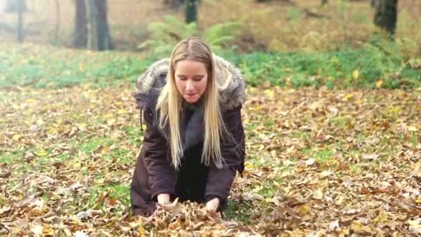 Frau wirft Blätter in die Luft — Stockvideo