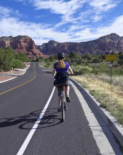 A Woman Bikes Toward Red Rocks in Sedona — Stock Photo, Image