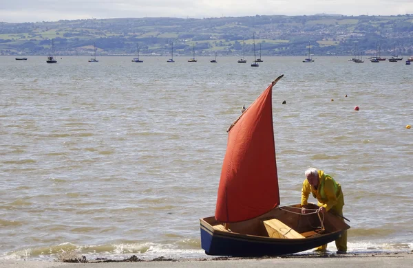 Um Dinghy azul com uma vela vermelha — Fotografia de Stock