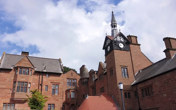 Una antigua casa señorial y torre del reloj — Foto de Stock