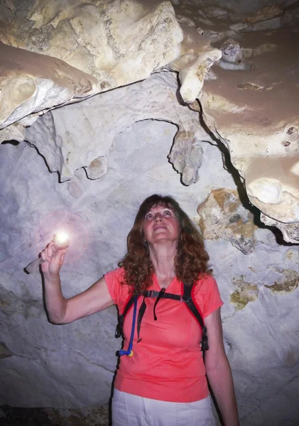 A Woman Examines Rock Formations in a Cave — Stock Photo, Image