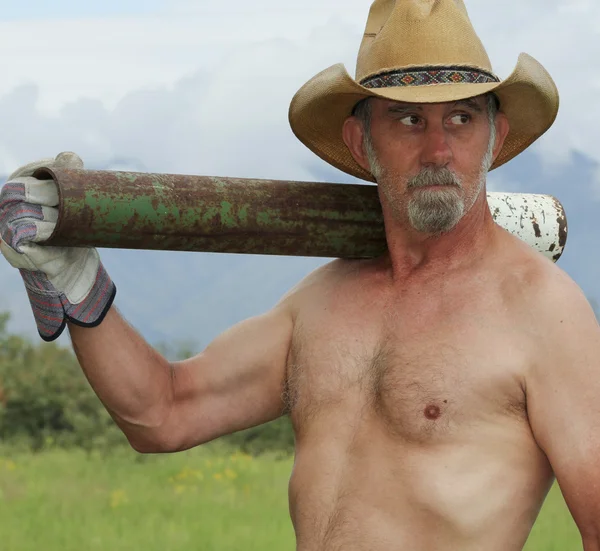 A Shirtless Cowboy Shoulders a Fence Post Driver — Stock Photo, Image