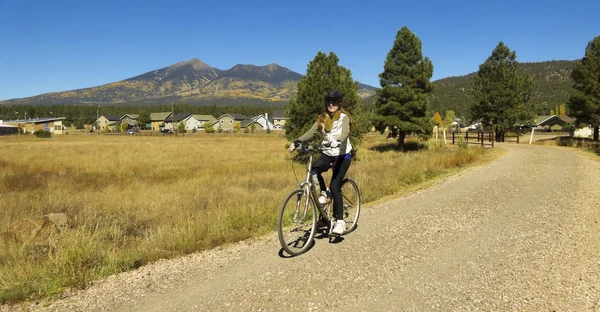 Женщина-велосипедистка едет осенью — стоковое фото