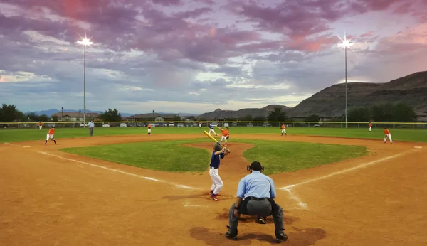 A Player Bats in a Twilight Baseball Game