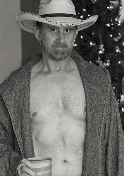 Un vaquero con una túnica abierta junto a un árbol de Navidad — Foto de Stock