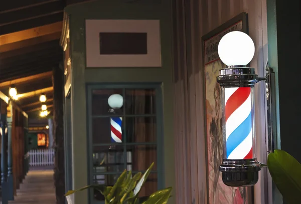 Un poteau de coiffeur lumineux sur un porche de magasin — Photo
