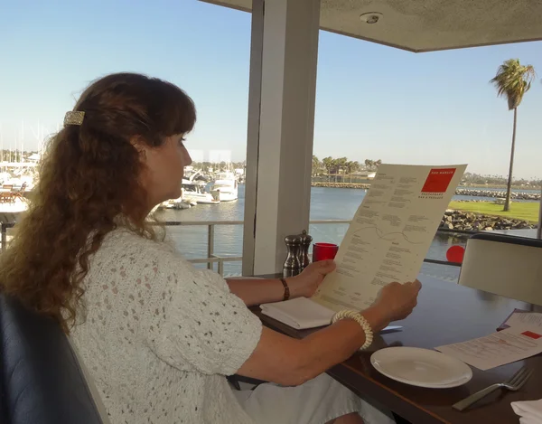 A Woman Reads the Menu at the Red Marlin — Stock Photo, Image