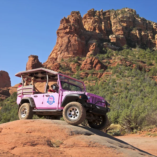 Ein pinkfarbener Jeep fährt kaputte Pfeilspur hinunter — Stockfoto