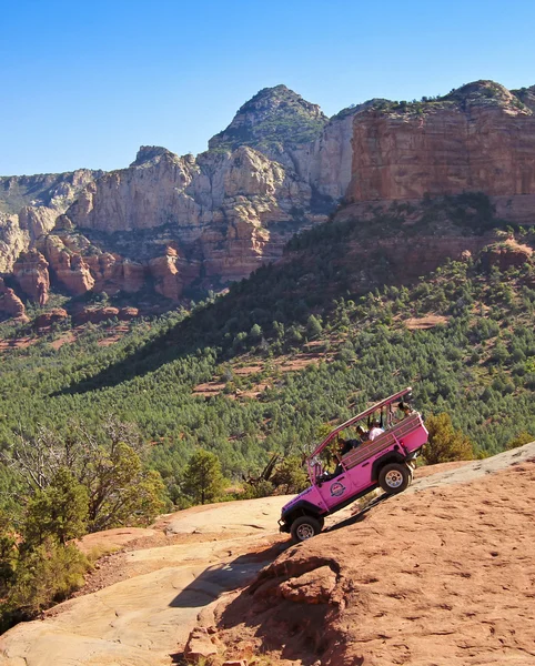 Ein pinkfarbener Jeep fährt kaputte Pfeilspur hinunter — Stockfoto