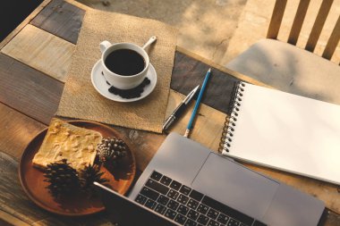 Kahve fincanı sıcak ve sabahları laptopla evde çalışıyor.