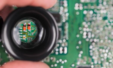 Yeşil PCB arka planında siyah hoparlördeki küçük elektronik parçalar. Büyütülmüş kırmızı yarı iletken diyotların, el lenslerindeki kondansatörlerin görüntüsü bulanık baskılı devre kartında beyaz bokeh ile.