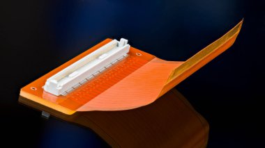 Beyaz konnektörlü turuncu esnek devre kartı ve siyah arka planda yansıması var. Eğri büğrü plastik PCB ile sanatsal hayat. LCD ekranında paralel sinyal iletimi için elektronik aygıt.