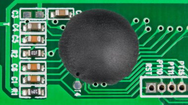 Epoksi yapışkan kaplamalı entegre devre doğrudan yeşil bir PCB detayına yerleştirilmiş. Güvertede çip ve yüzeye monte teknolojisi. Parçalanmış elektrik voltaj testinin içindeki küçük elektronik bileşenler..
