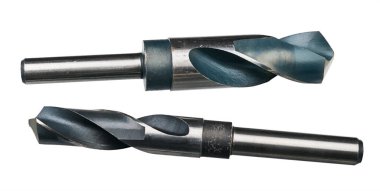 Yüksek hızlı çelikten iki keskin matkap ucu beyaz arka planda izole edilmiş. Silindirik bıçaklı spiral oyuk kesicilerin yakın çekimi. Metalde kesin delikler açmak için kesme araçları.