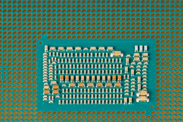 Detail of modern micro processor for computer motherboard. Land grid array packaging. Central processing unit from bottom. Closeup of electronic resistors and capacitors. Electrical engineering. Tech.