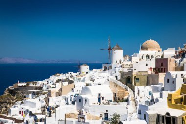 Yunanistan 'ın Santorini adasında güneşli bir günde Oia köyündeki eski yel değirmeni.