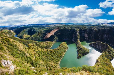 Kayalık Uvac nehrinin taşları güneşli günde, Sırbistan 'ın güneybatısında dolanıyor.