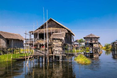 Antik evler ve onların Inle Gölü 'ndeki sudaki yansımaları, Myanmar. (Burma)