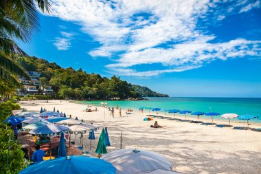 Tayland, Phuket 'te güneşli bir günde kimliği belirsiz insanlar Kata sahilinde dinleniyor.. 