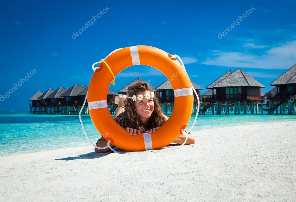 Happy girl with life vest at topical beach on Olhuveli island in Maldives.