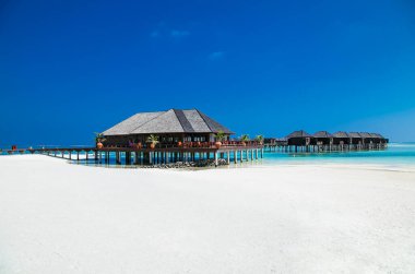 Olhuveli Adası, Maldivler 'de dinlenmek için wihte plajı ve turkuaz suyu olan güzel bir tropikal tatil köyü. Mercan resifli beyaz kumsal. Rahatlamak, güneşlenmek ve şnorkelle yüzmek için en iyi plaj..