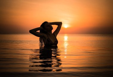 Güzel bir kızın silueti sonsuz havuzda eğleniyor. Maldivler. 