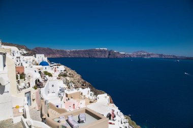 Yunanistan 'ın Santorini adasındaki güneşli bir günde Oia köyünden panoramik manzara