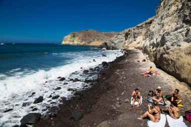 Santorini, Yunanistan. 15 Haziran 2016: Kızıl plajdaki insanlar, Santorini 'deki ünlü ve güzel plajlar. Yunanistan. Akrotiri köyü ve antik yerleşim yeri yakınlarında yer almaktadır..