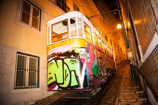 Lizbon, Portekiz - 31 Ekim 2018: Lizbon 'da geceleri Alfama ilçesinin eski dar bir sokağında eski bir geleneksel tur tramvayı. Portekiz.