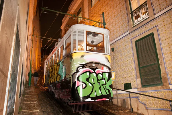 Lizbon, Portekiz - 31 Ekim 2018: Lizbon 'da geceleri Alfama ilçesinin eski dar bir sokağında eski bir geleneksel tur tramvayı. Portekiz.