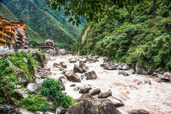 Urubamba nehri akıntısı ve arkada Machu Picchu Pueblo, kutsal vadi, Cusco bölgesi, Peru.