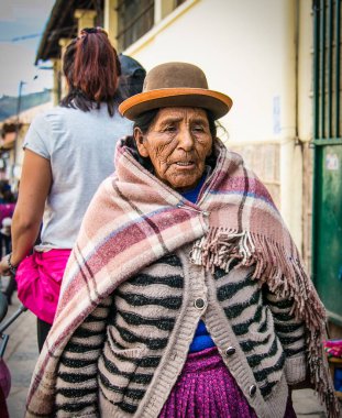 Cusco, Peru - 9 Ocak 2019: Cusco City, Peru 'nun ana caddesinde geleneksel kostümlü yaşlı kadın.