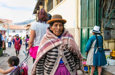 Cusco, Peru - 9 Ocak 2019: Cusco City, Peru 'nun ana caddesinde bakım çantasıyla yaşlı bir quechua kadını.