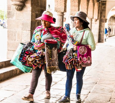 Cusco, Peru - 9 Ocak 2019: Cusco City, Peru 'da renkli masa örtüleri ve kumaşlar satan iki genç Keçuva kadını.
