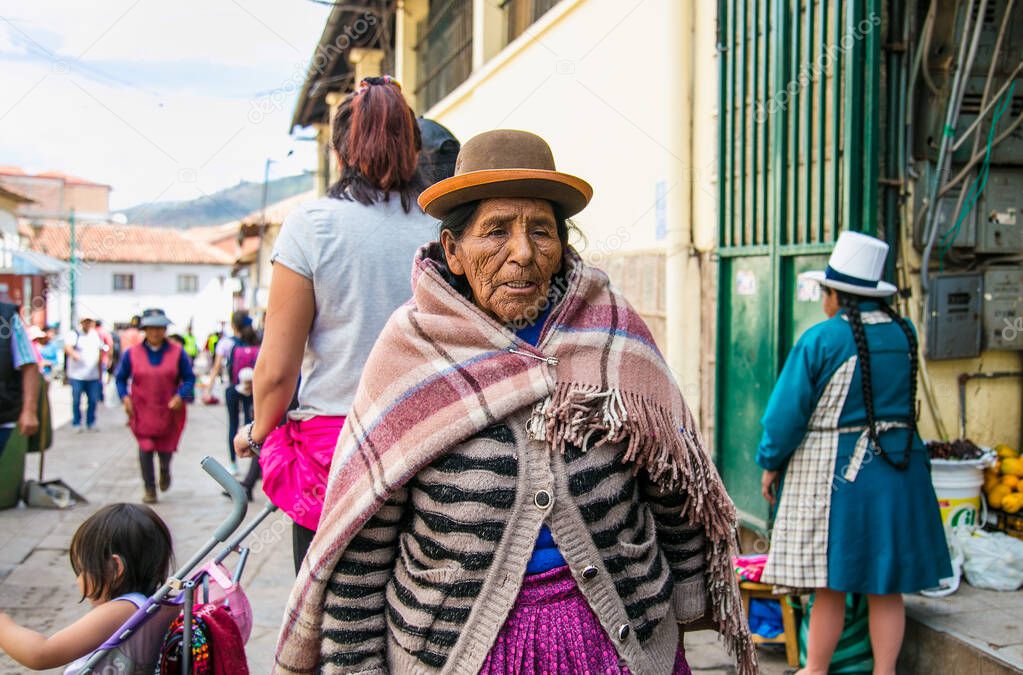 Cusco , Peru- Jan 9, 2019: Old  quechua woman with her caring bag in main street of  Cusco City, Peru.