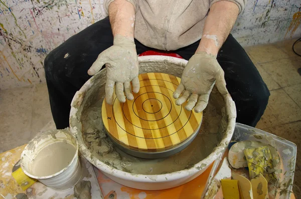 Clay covered potter hands — Stock Photo, Image