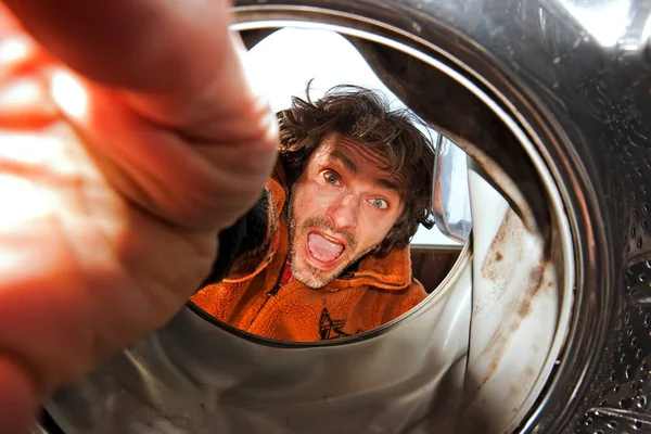 检查内部的一台洗衣机的惊讶的男人 — 图库照片