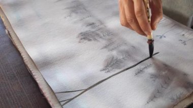 Suluboya sanatçısı, bir sanat eseri yapıyor.