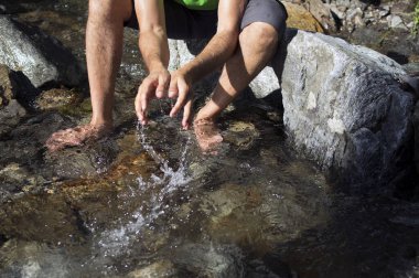 Tanınmayan adam derede temiz suyla oynuyor.
