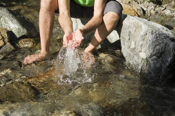 誰も知らない男が小川で澄んだ水で遊ぶ — ストック写真