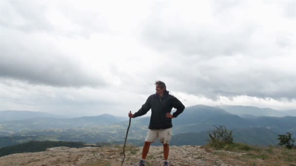 Homem de pé no topo de uma montanha — Vídeo de Stock