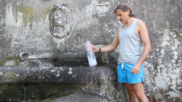 Hombre llenando una botella — Vídeo de stock