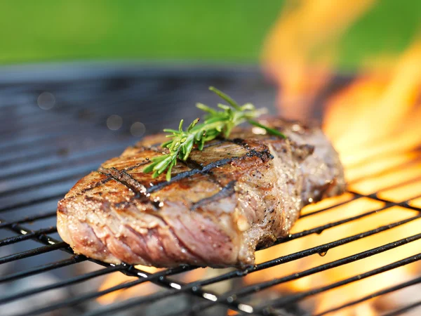 Steak mit Flammen auf Grill — Stockfoto