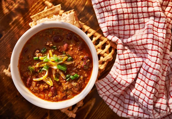 Kom van chili met kaas en groene uien — Stockfoto