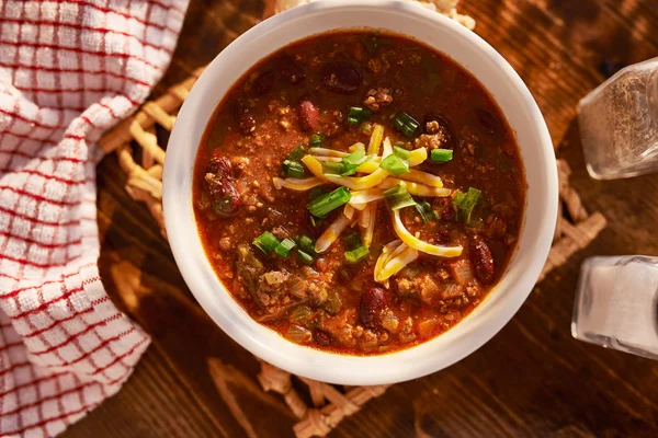 Skål med chili med ost och grön lök — Stockfoto