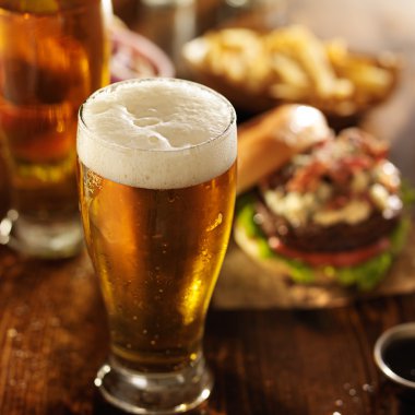 Cold beer with foamy head and burgers clipart