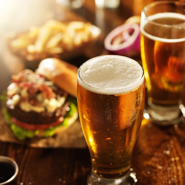 La bière étant versée dans le verre sur la table — Photo