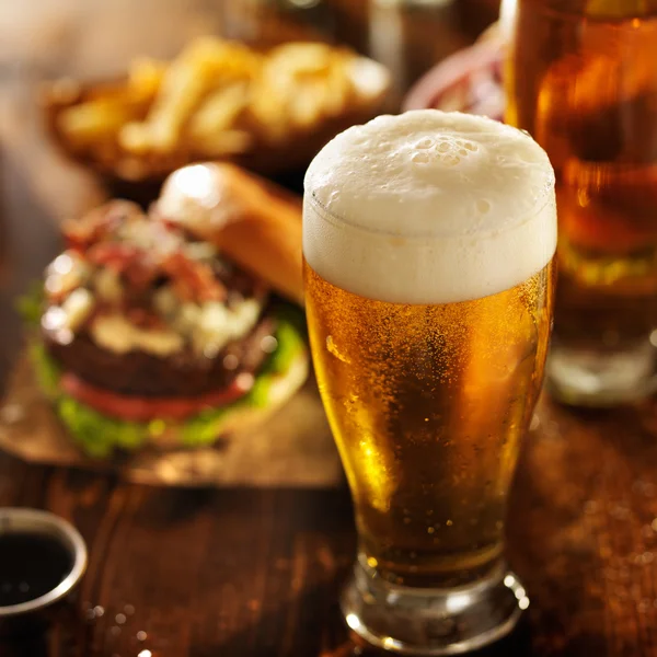 La bière étant versée dans le verre sur la table — Photo