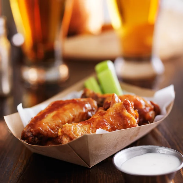 Buffalo chicken wings in basket with celery — Stock Photo, Image